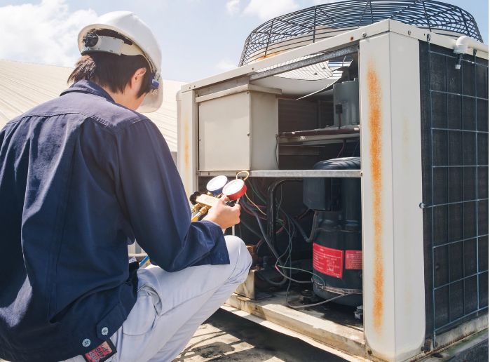 Technician performing AC repair on a commercial unit in Durham, NC